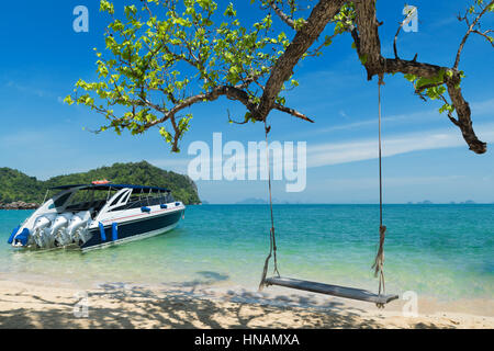 Holzschaukel Stuhl hängen am Baum in der Nähe von Strand von Island in Phuket, Thailand. Sommer Urlaubsreisen und Urlaub-Konzept. Stockfoto