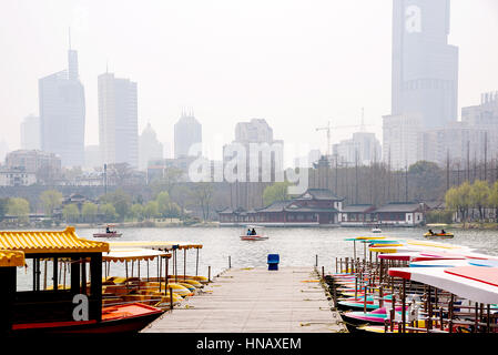 Boote auf Xuanwu See mit Gebäuden und Nanjing Wand im Hintergrund Stockfoto