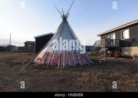 Tipi im Hinterhof eines Hauses, Northern Quebec. First Nations in Kanada halten oft ihre schönen Traditionen lebendig mit einem Tipi auf ihrem Grundstück. Darin haben sie Familienfeiern, feste und traditionelle Speisen kochen. Stockfoto