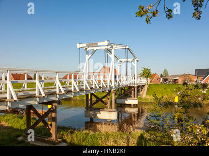 Steinkirchen, Deutschland - 8. Mai 2016: Hölzerne Zugbrücke über Lühe Fluss in der Region Altes Land Niedersachsen am Abend Licht, Touristen mit Fahrrad Stockfoto