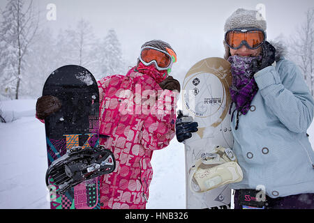 Zwei Frauen mit Snowboards in Asahidake, Daisetsuzan Nationalpark, Hokkaido, Japan Stockfoto