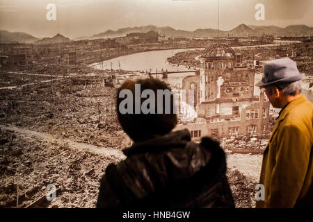 Besucher sieht ein Foto von Hiroshima nach der Atombombe Explosion, Hiroshima Peace Memorial Museum, Hiroshima, Japan Stockfoto