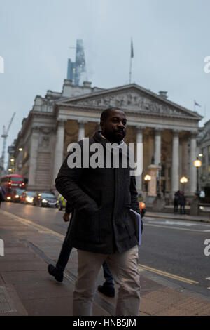 Eine schwarze Stadt Arbeitskraft geht vorbei an der Neo-römischen Säulen der Royal Exchange am 9. Februar 2017, in der City of London, England. Stockfoto