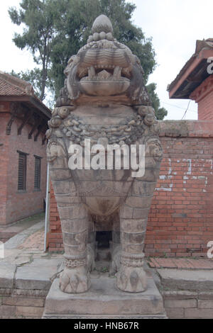 Eine stilisierten geschnitzten steinernen Löwen steht Wache vor einem Tempel in Bhaktapur Ortschaft von Kathmandu, Nepal Stockfoto