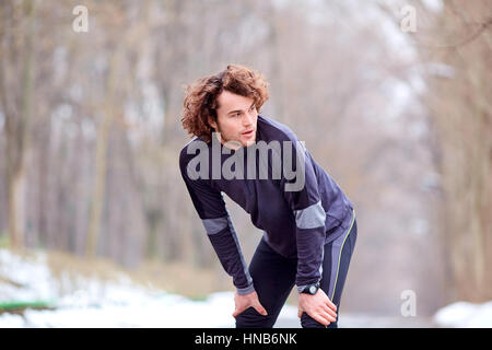 Lockigen Jüngling im Park nach dem Joggen Stockfoto