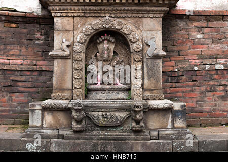 Steinbildhauerei von Vishnu, einem Hindu-Gott, in einem Tempel in Bhaktapur, Kathmandu, neben dem Wasserteich Stockfoto