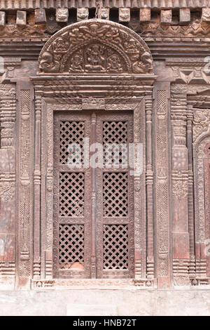 Reich geschnitzte Lattic-Arbeit Holztür eines alten Hauses, mit einem hölzernen Türsturz geschnitzt mit Hindu-Gottheiten in Bhaktapur, Kathmandu Stockfoto