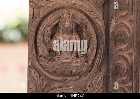 Holzschnitzerei von Hindu-Gottheiten und himmlische Nymphen schmücken die Wände eines Gebäudes in Bhaktapur, Kathmandu Stockfoto