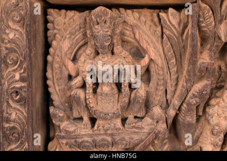 Holzschnitzerei von Hindu-Gottheiten und himmlische Nymphen schmücken die Wände eines Gebäudes in Bhaktapur, Kathmandu Stockfoto