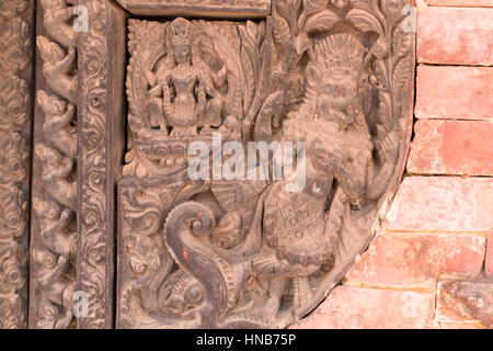 Holzschnitzerei von Hindu-Gottheiten und himmlische Nymphen schmücken die Wände eines Gebäudes in Bhaktapur, Kathmandu Stockfoto