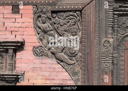 Holzschnitzerei von Hindu-Gottheiten und himmlische Nymphen schmücken die Wände eines Gebäudes in Bhaktapur, Kathmandu Stockfoto