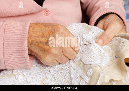 Nahaufnahme von einer alten Frau Hand nähen Stockfoto