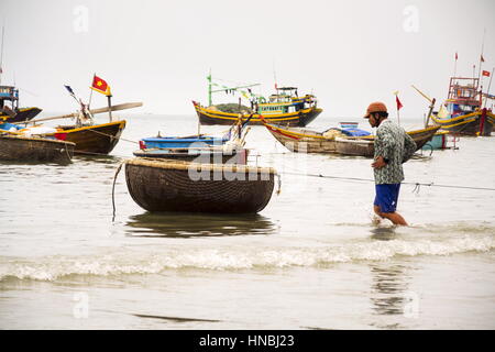 MUI NE, VIETNAM - Februar 7: Fischer mit bunten Fischerbooten am 7. Februar 2012 in Mui Ne, Vietnam. Stockfoto