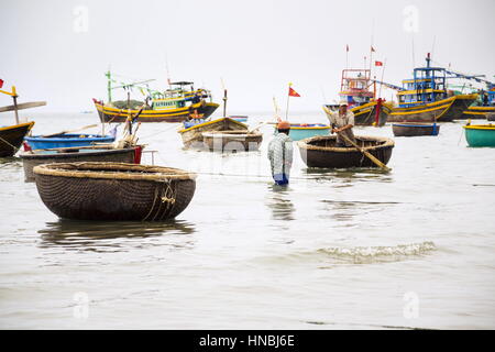 MUI NE, VIETNAM - Februar 7: Fischer mit bunten Fischerbooten am 7. Februar 2012 in Mui Ne, Vietnam. Stockfoto