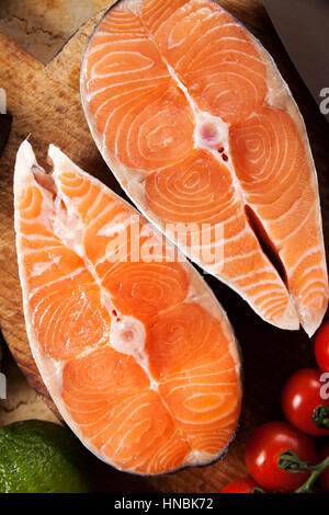 Zwei frischen rohen Lachs Steaks mit Tomaten auf Marmortisch Stockfoto