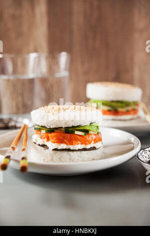 Sushi-Menü mit Burger aus Reis und geräucherter Lachs, Avocado, leichte Käse und nori Stockfoto