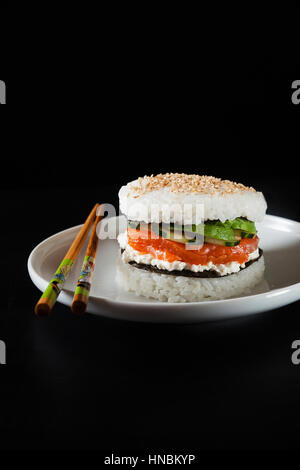 Sushi-Platte mit Burger aus Reis und geräucherter Lachs, Avocado, leichte Käse und nori Stockfoto