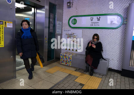 Mädchen-SMS auf Smartphone und Frau Aufzug in Gangnam u-Bahn Bahnhof verlassen. Seoul, Südkorea, Asien Stockfoto