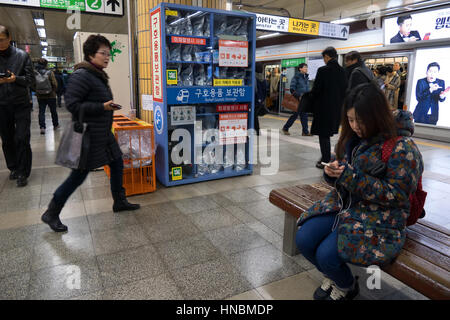 Mädchen-SMS auf Smartphone und Gasmasken gegen Terroranschläge in Gangnam u-Bahn Bahnhof. Seoul, Südkorea, Asien Stockfoto