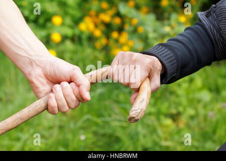 Depressive ältere faltige Hand halten ihres Stocks Stockfoto