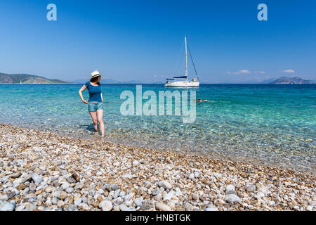 Frau im Meer Blick über ihre Schulter auf paar schwimmen, Ithaki, Griechenland Stockfoto