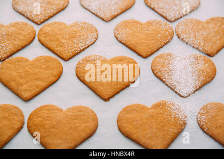 Beregnung Puderzucker auf Herz geformt cookies Stockfoto
