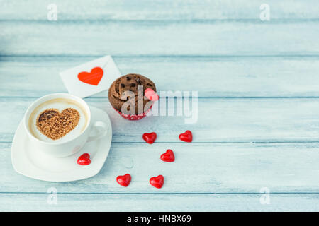 Cappuccino Kaffee mit Schokolade Muffin und Herz-Form-Dekorationen Stockfoto
