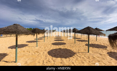 Liegestühle und Sonnenschirme am Strand, Algarve, Portugal Stockfoto