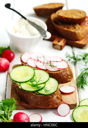 Belegte Brötchen mit Frischkäse, Radieschen und Gurken Stockfoto