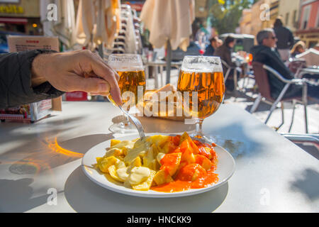 Patatas Bravas und Patatas Alioli mit zwei Gläsern Bier auf eine Terrasse. Madrid, Spanien. Stockfoto