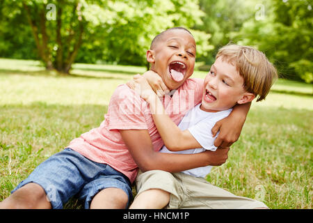 Zwei jungen haben Spaß im Park und Ringen beim Lachen Stockfoto