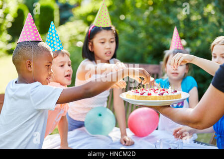 Interracial Kinder mit Kuchen auf Geburtstagsparty Stockfoto