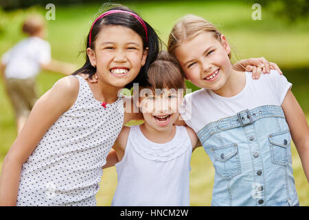 Drei lachende Mädchen als Freunde in interkulturellen glückliches Team Porträt Stockfoto