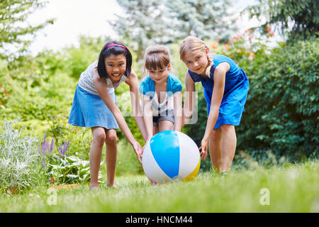 Drei Kinder spielen als Team mit Ball im Sommer Stockfoto