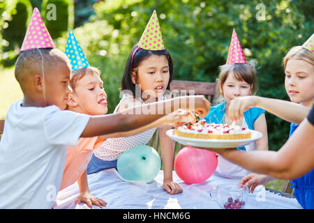 Viele interracial Kinder essen Kirschkuchen auf Geburtstagsparty im Sommer Stockfoto