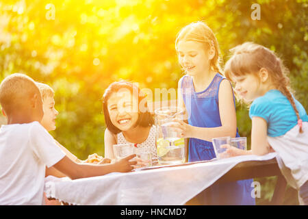 Kinder haben Spaß an Kinder Geburtstag Party und trinken Limonade im Sommer Stockfoto