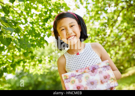 Asiatin als Geburtstagskind mit Geburtstagsgeschenk Stockfoto