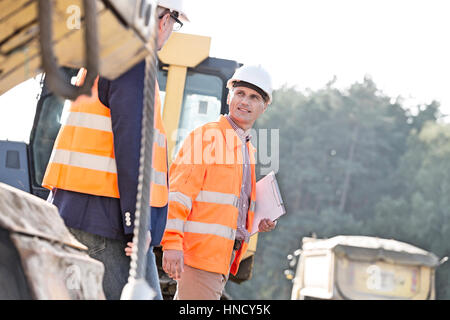 Vorgesetzten sprechen während des Gehens auf Baustelle Stockfoto