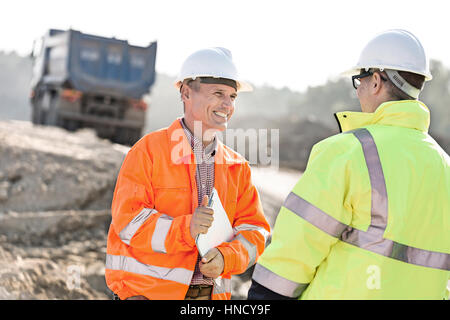 Glücklich Ingenieur diskutieren mit Kollegen bei der Baustelle am sonnigen Tag Stockfoto