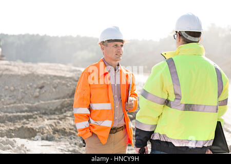 Aufsichtsbehörden auf Baustelle am sonnigen Tag diskutieren Stockfoto