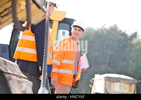 Aufsichtsbehörden auf Baustelle am sonnigen Tag diskutieren Stockfoto