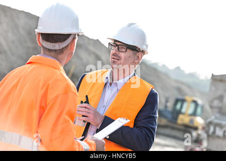 Architekten auf Baustelle am sonnigen Tag diskutieren Stockfoto