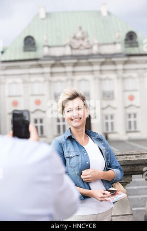 Zugeschnittenes Bild Mann fotografiert Frau außerhalb Gebäude Stockfoto