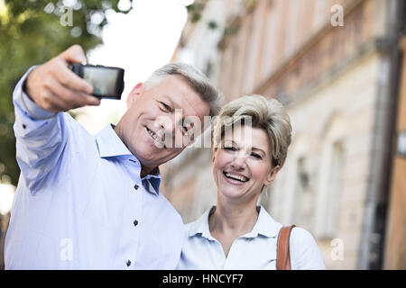 Fröhliches Paar mittleren Alters unter Selbstporträt im freien Stockfoto