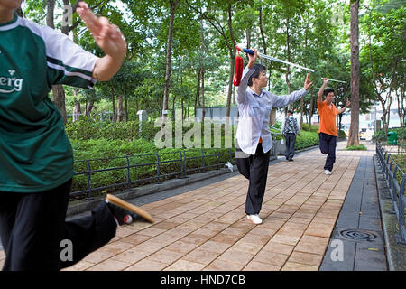 Street Scene, Bewegung, Kampfkunst, Menschen üben von Tai Chi mit Schwertern am frühen Morgen in den Victoria Park, Hong Kong, China Stockfoto