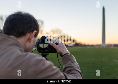 Mann unter Bild des Washington Monument während des Sonnenuntergangs in DC Stockfoto