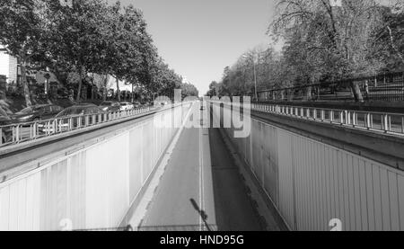 Schwarzen & weißen Straßenszene in Madrid.  Sonne scheint hell auf Calle del Alfonso wo es einen Tunnel, der unter einer Kreuzung tritt oben ausgeführt wird. Stockfoto