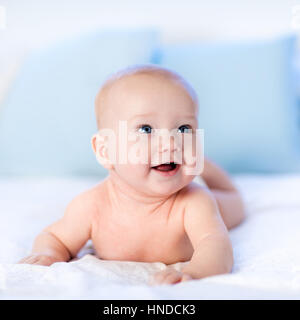 Jungen tragen Windel in weißen sonnigen Schlafzimmer. Neugeborenes Kind im Bett entspannen. Kindergarten für Kinder. Textil- und Bettwäsche für Kinder. Familie Morgen um Uhr Stockfoto