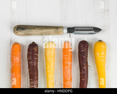 Regenbogenfarbenen Karotten kochen Zutaten mit dem Sparschäler Stockfoto