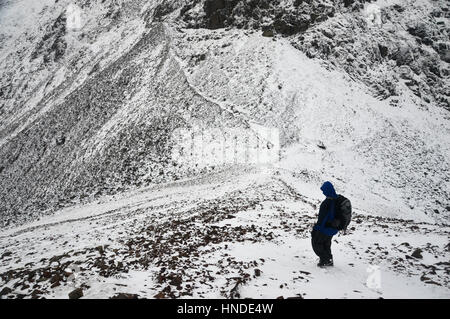 Einsame Walker Climbing auf windigen Lücke von Wainwright Green Gable im Borrowdale, Nationalpark Lake District, Cumbria, UK. Stockfoto